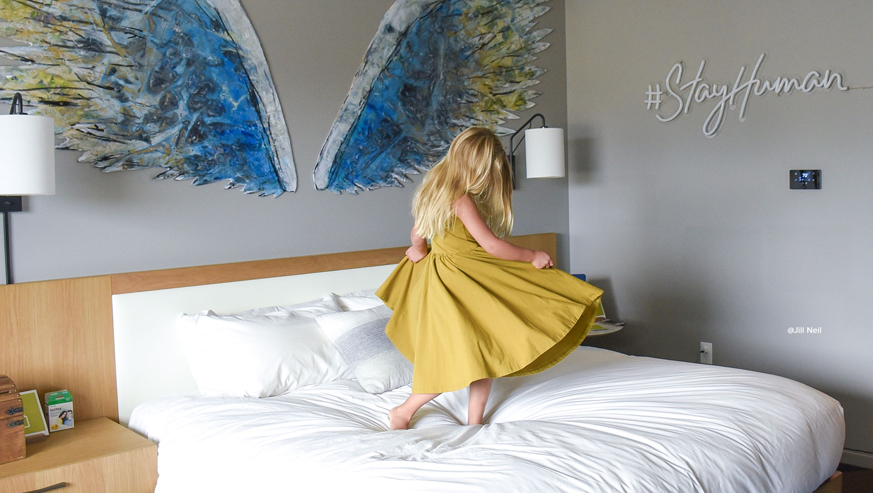 Girl jumping bed in Everly Guestroom 301