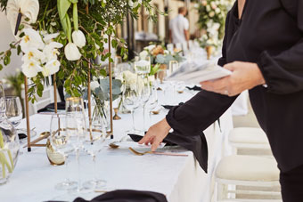 someone setting wedding reception table
