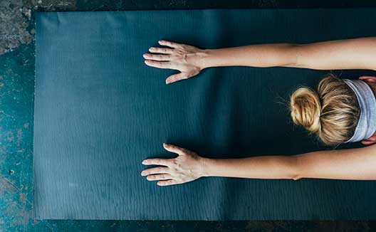 woman stretching on yoga mat
